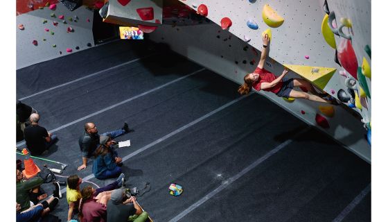 Competition climber on indoor boulder problem