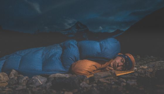 Man sleeps with mountain behind