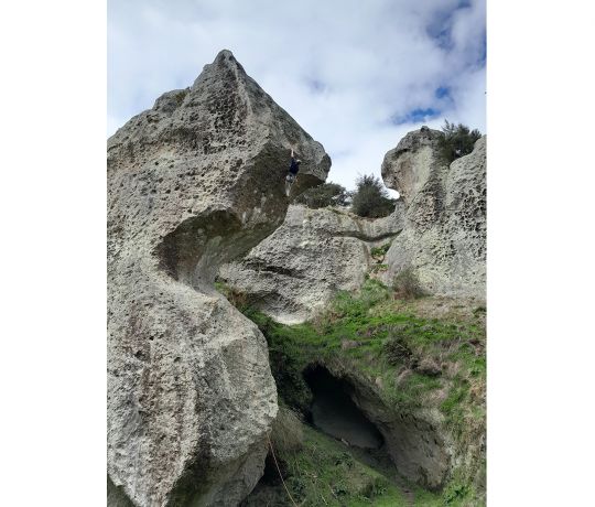 Climber on absurdly-shaped rock formation