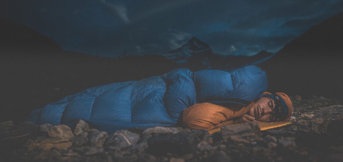 The Alpinist Man sleeps with mountain behind