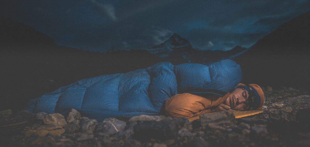 Man sleeps with mountain behind